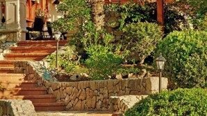 A stone staircase leading up to a wooden pergola with a palm tree and potted plants. - Sheraton Mallorca Arabella Golf Hotel (Palma de Mallorca)
