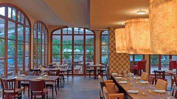Ein geräumiges Restaurant mit hohen, gewölbten Fenstern, Holztischen und -stühlen.