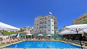 Una piscina al aire libre, sombrillas, tumbonas