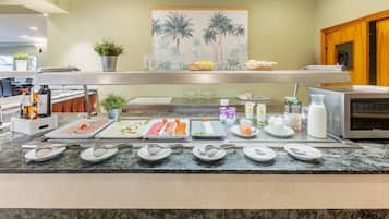 Mostrador de buffet con diversos alimentos y salsas.