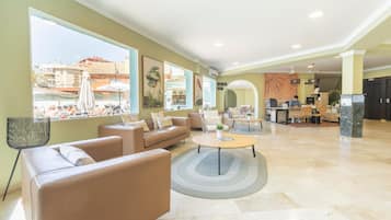 Un amplio salón con sofá, mesa de centro y vistas a la ciudad.