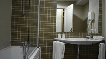 Un baño con bañera, lavamanos y espejo.