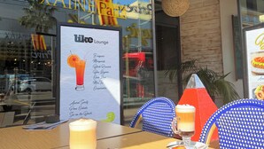 A table with a drink and pastries outside a building with a sign reading 'XAINES'.