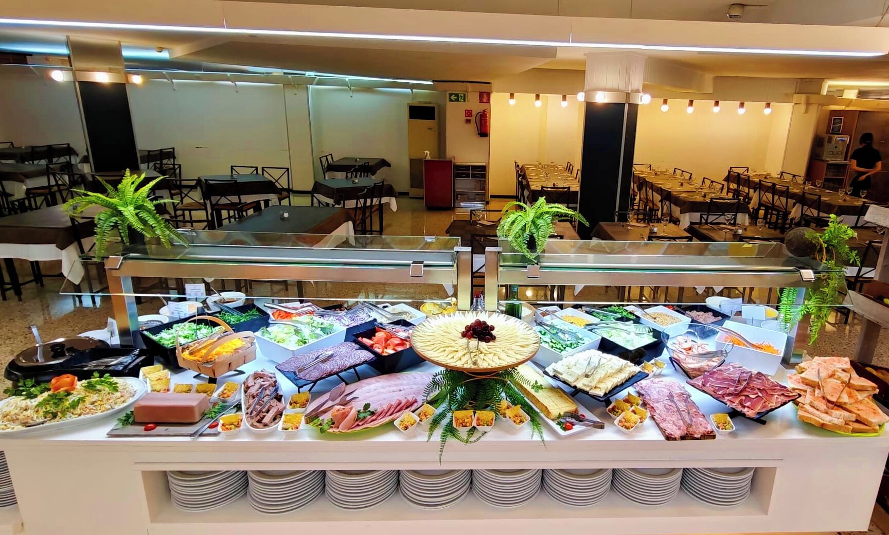 A buffet with various food items and a glass display case.