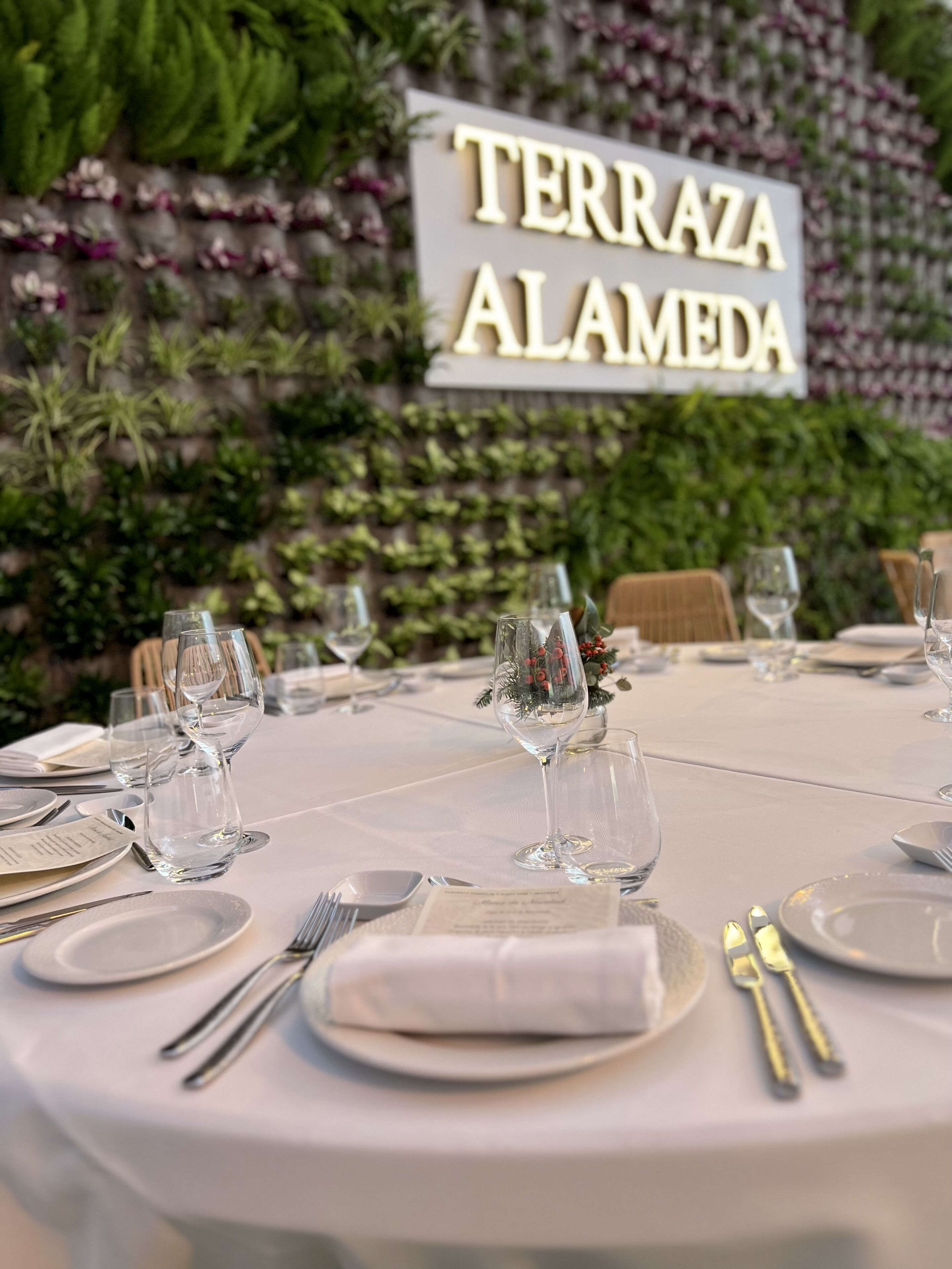 A table set for a meal with a sign reading "TERRAZA ALAMEDA" in the background.