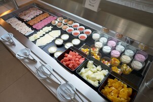 Een buffet met diverse gerechten, waaronder vleeswaren, kazen, fruit en desserts.