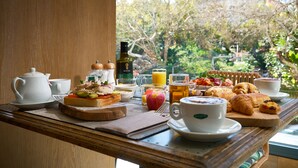 A breakfast tray with a teapot, cups, croissants, and a bottle of olive oil. - Obal Hotel Marbella (Marbella)