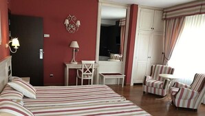 A hotel room with a large bed, two armchairs, a small table, and a desk. - Hotel Leonor Miron (Soria)