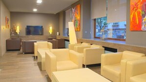 A modern waiting area with leather sofas and a flat-screen TV. - Rias Bajas (Pontevedra)