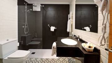 Un baño moderno con inodoro, bidé, ducha y lavamanos.