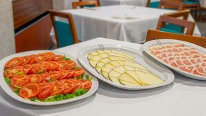 A buffet table with three dishes: sliced tomatoes, cheese, and salmon. - Rias Bajas (Pontevedra)