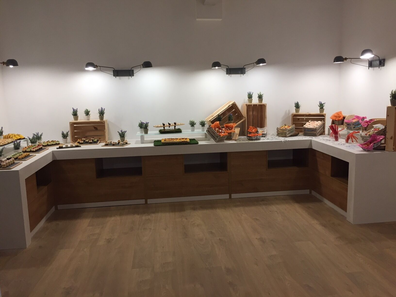 A buffet setup with various food items and decorative plants.