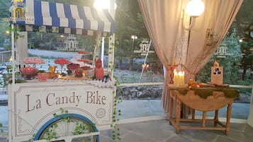 A La Candy Bike kiosk with a variety of sweets and a small table with candles and a lantern.