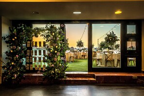 An entrance with a view of an outdoor dining area, a sign reading 'SALIDA', and a staircase leading up.
