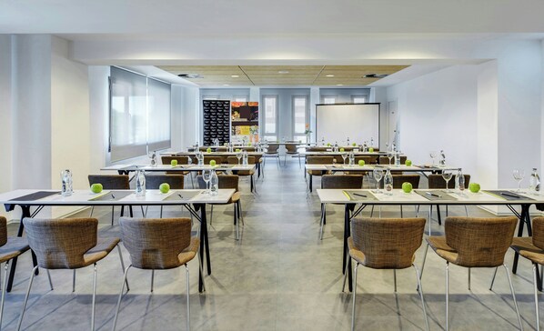 A conference room with tables, chairs, and a projector screen. - Sercotel Gran Hotel Zurbarán (Badajoz)