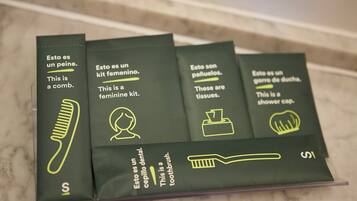 Ein Set an Toilettenartikeln in einer transparenten Plastikbox, mit Aufschriften in Englisch und Spanisch.
