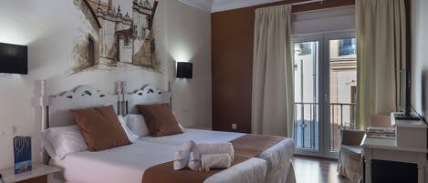 Une chambre d’hôtel avec un grand lit, un bureau, une chaise, une télévision et un balcon avec des rideaux.