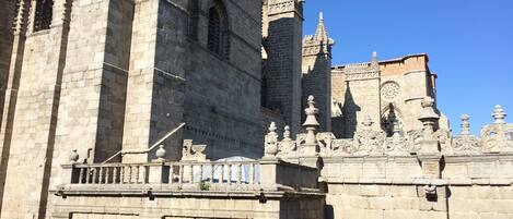A historic stone building with a prominent tower, intricate architectural details, and a clock tower.