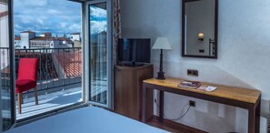 Enjoy a room with a balcony offering a view of the surrounding area, a console table, and a TV.
