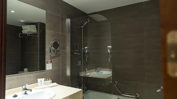 A modern bathroom with a glass-enclosed shower, a sink, and a mirror.