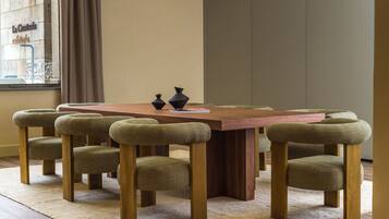 Un comedor con una mesa de madera y seis sillas tapizadas.