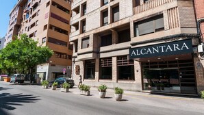 Un edificio de varios pisos con una fachada que muestra el rótulo "ALCANTARA".