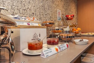 Un buffet della colazione con diverse pietanze e una macchina per il caffè.