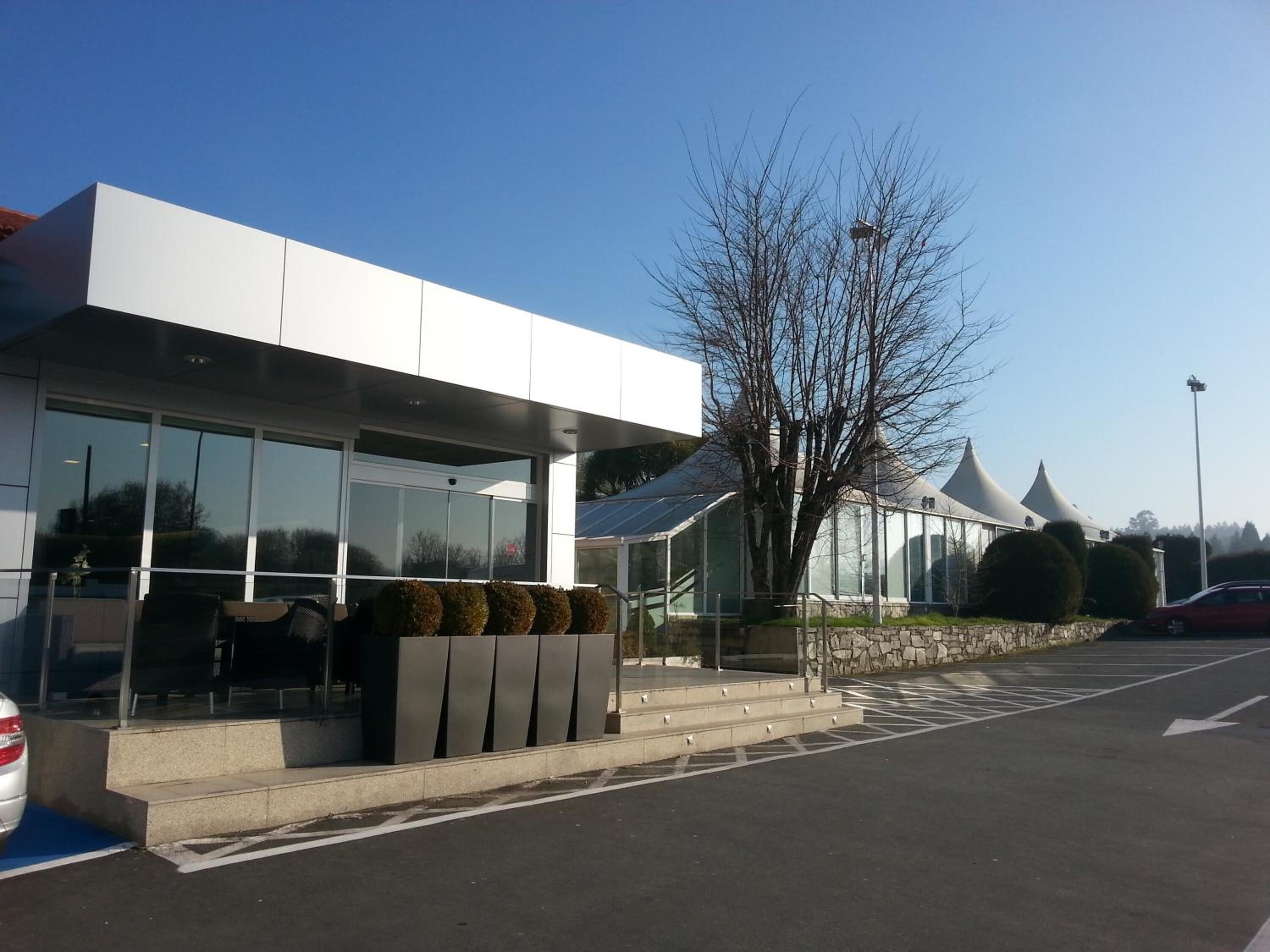 A modern building with large windows and a covered entrance.