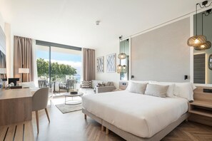 Ein modernes Hotelzimmer mit einem großen Bett, einem Schreibtisch und einem Balkon mit Blick.
