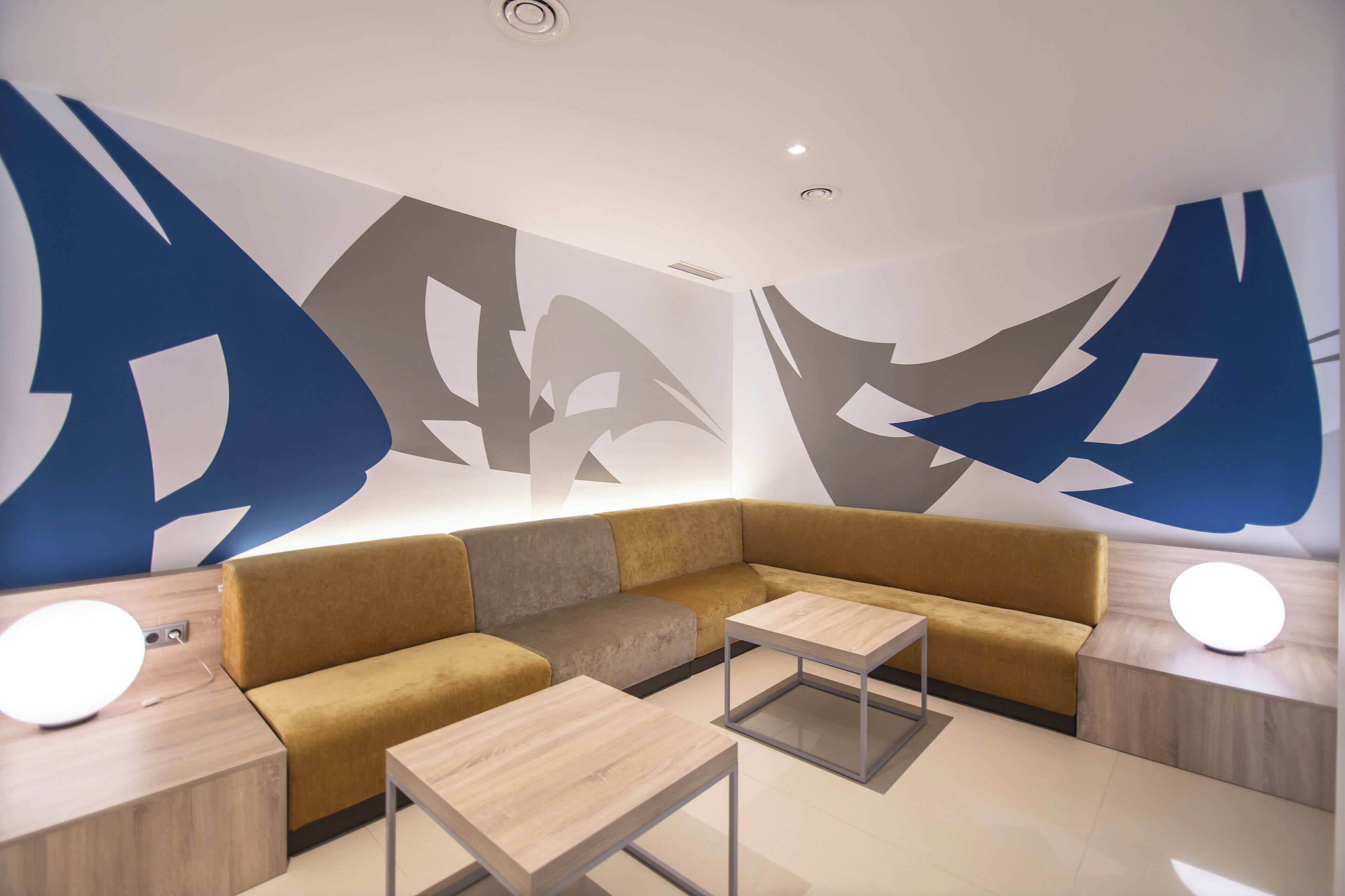 Una sala de estar moderna con un sofá modular, dos mesas auxiliares y una mesa de centro.