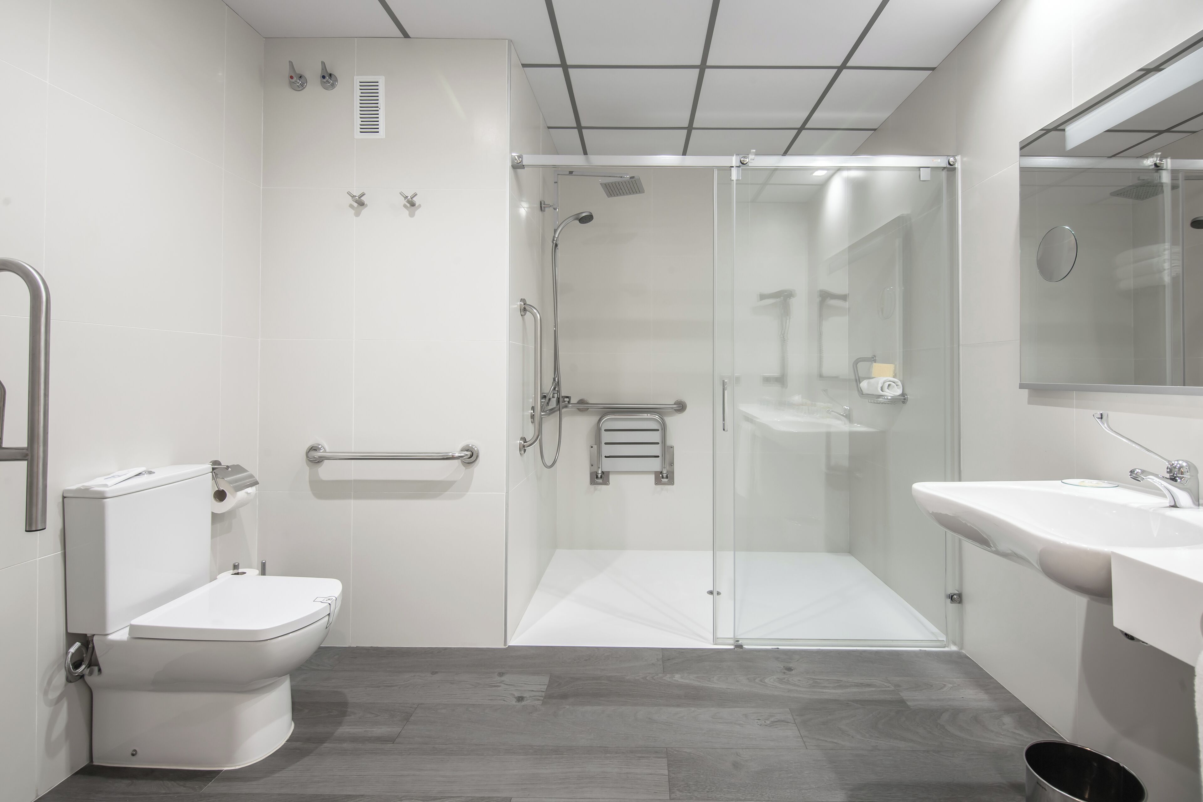 Une salle de bain moderne équipée de toilettes, d’une douche et d’un lavabo.