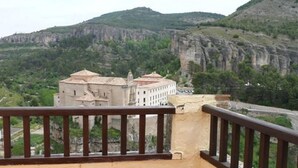 A view of a building with a balcony, surrounded by a mountainous landscape. - Posada de San José (Cuenca)