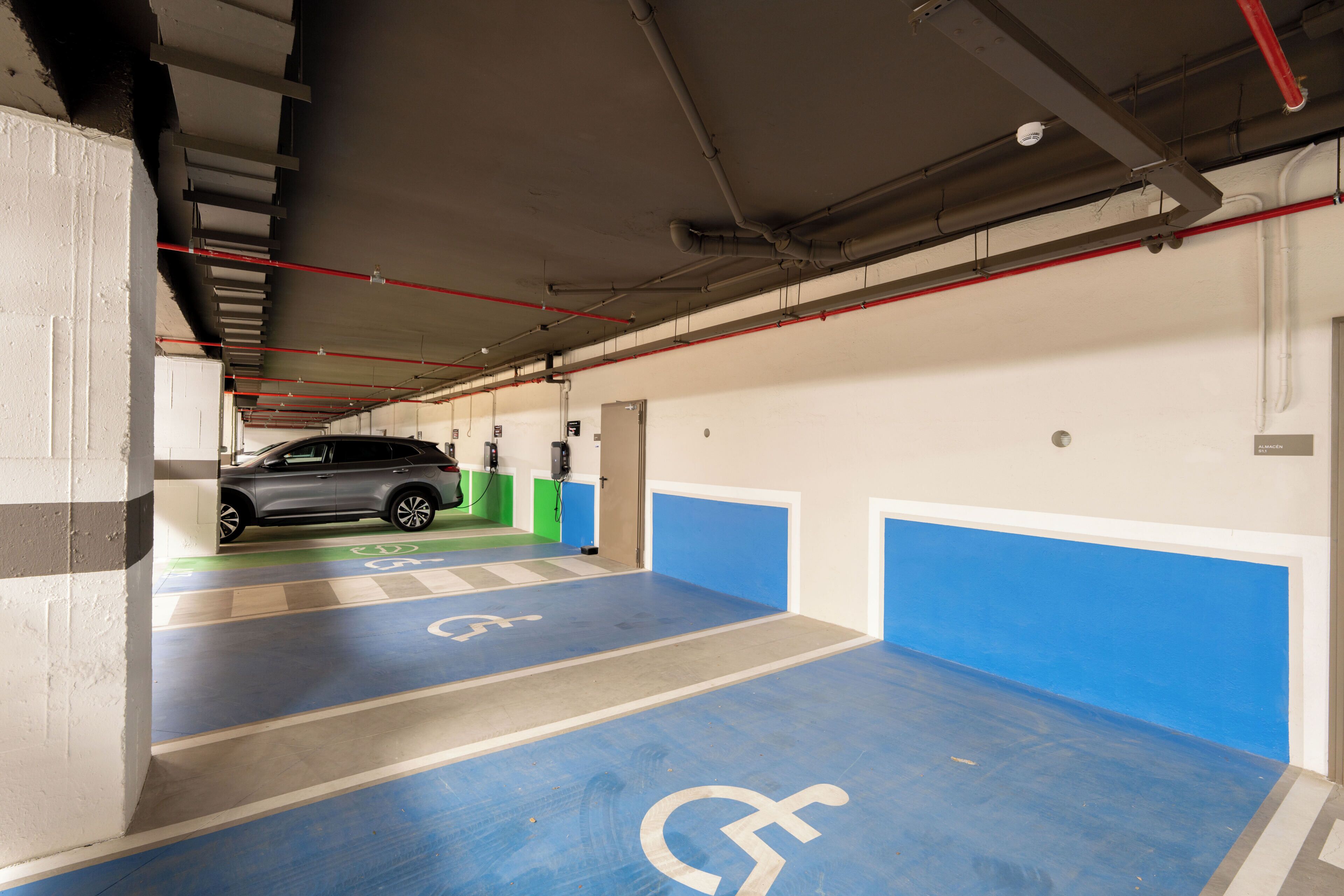 A parking garage with blue and white painted areas, including a handicapped parking space.