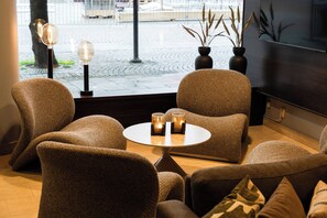 A seating area with a round table, two chairs, and a potted plant. - Best Western Malmia Hotel (Skelleftea)
