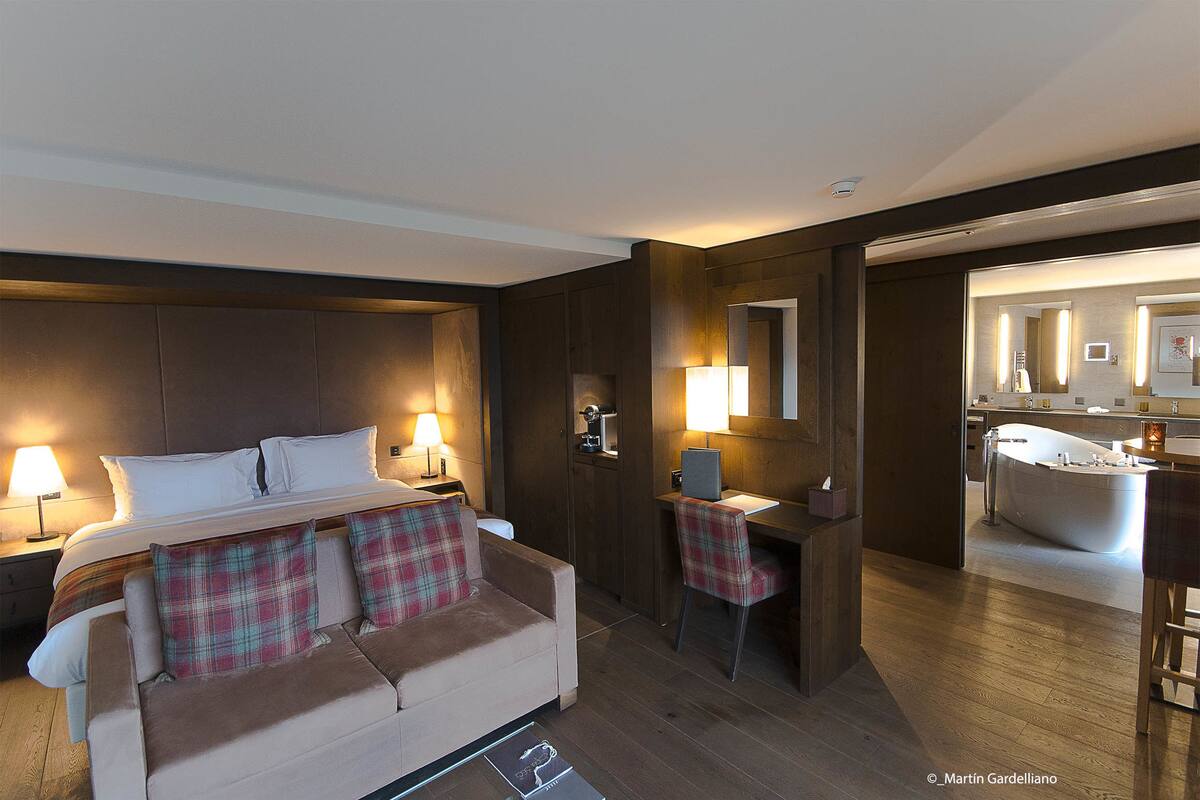 Una habitación de hotel con cama, sofá, escritorio y baño.