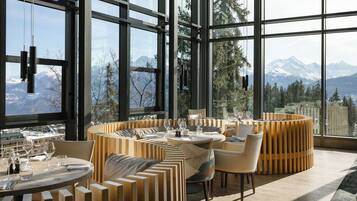 A modern dining area with a view of mountains through large windows.