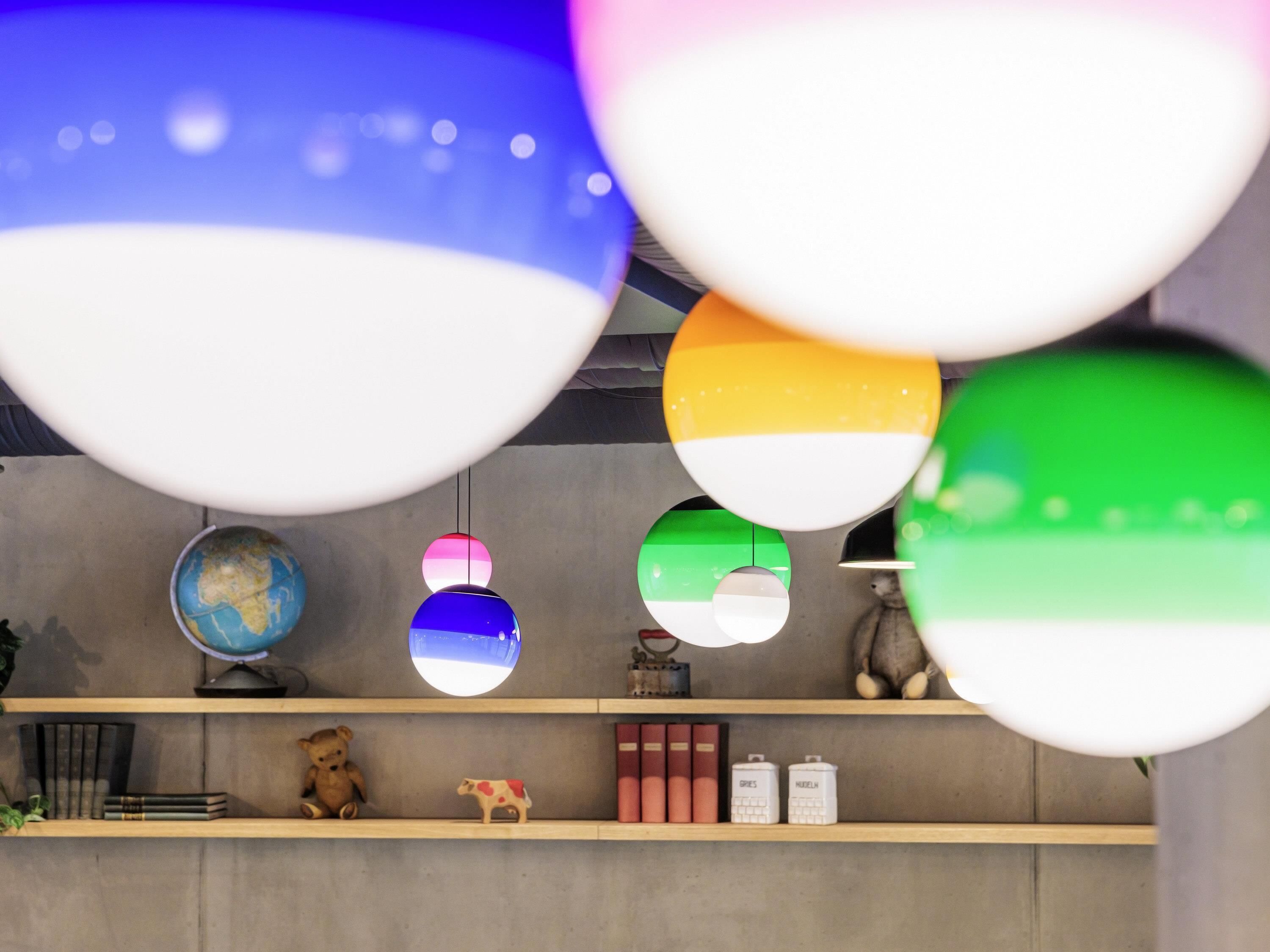 Una habitación con una estantería que muestra libros, un globo terráqueo, un oso de peluche y una pequeña figurita de vaca.