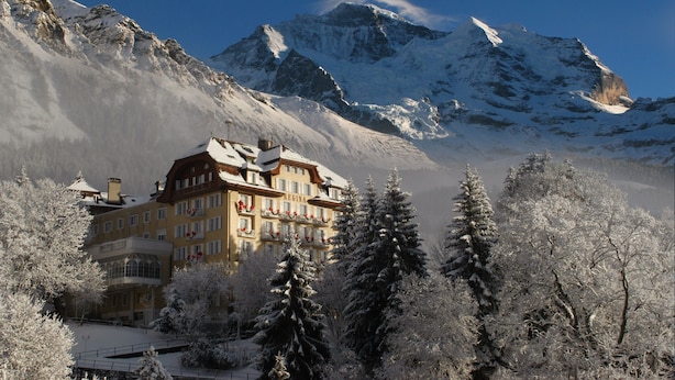 A snow-covered mountain resort with a prominent building featuring balconies and a sign reading "Regina". - Hotel Regina Wengen (Lauterbrunnen)