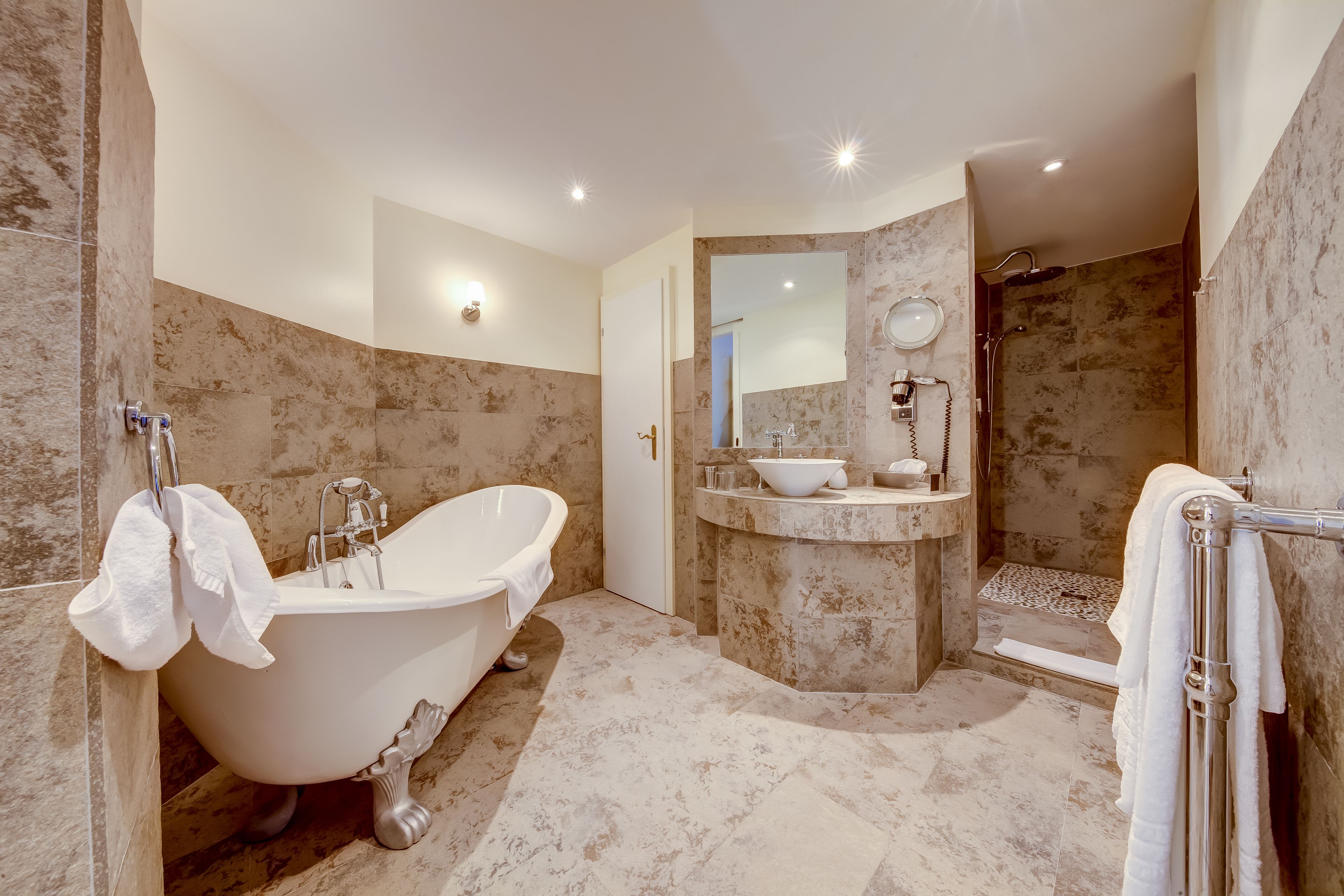 A modern bathroom with a freestanding bathtub, a walk-in shower, and a vanity with a sink and mirror.