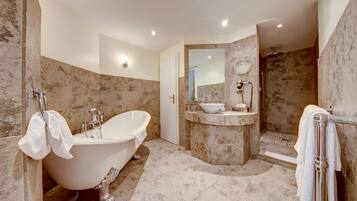 A modern bathroom with a freestanding bathtub, a walk-in shower, and a vanity with a sink and mirror.