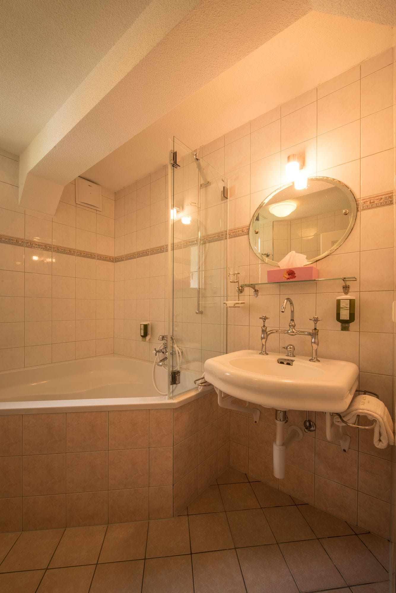 A bathroom with a bathtub, a sink, and a glass-enclosed shower.