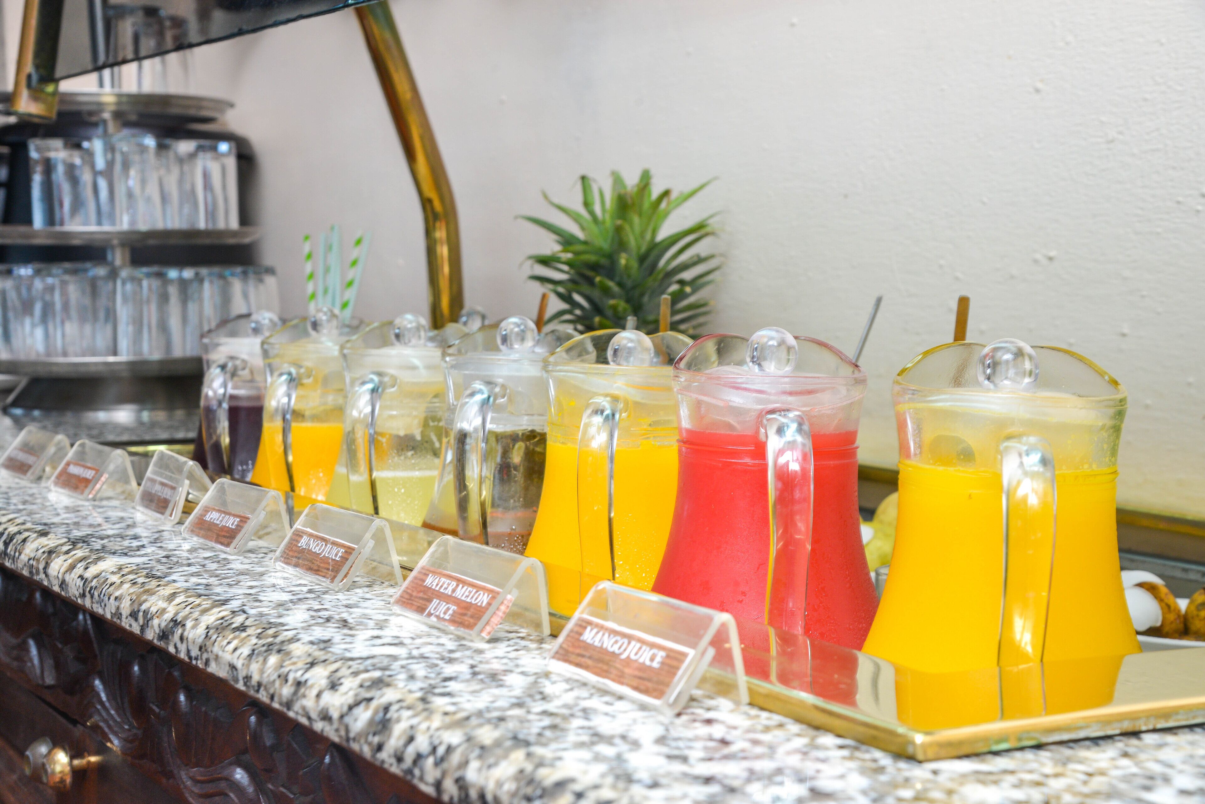 Een sapbar met verschillende fruit-sapjes, zoals mango, watermeloen en sinaasappel.