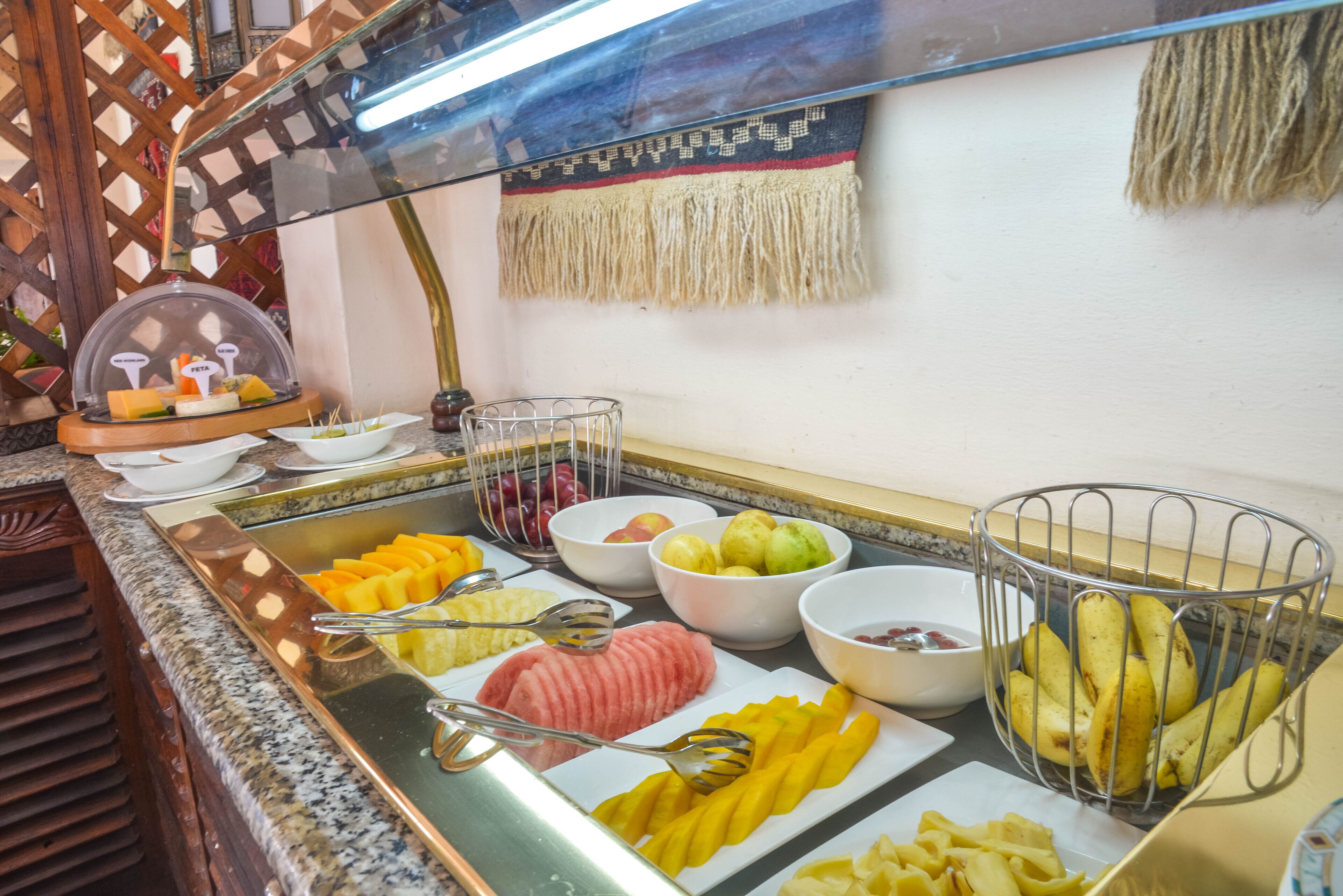A buffet with various fruits, vegetables, and cheeses.