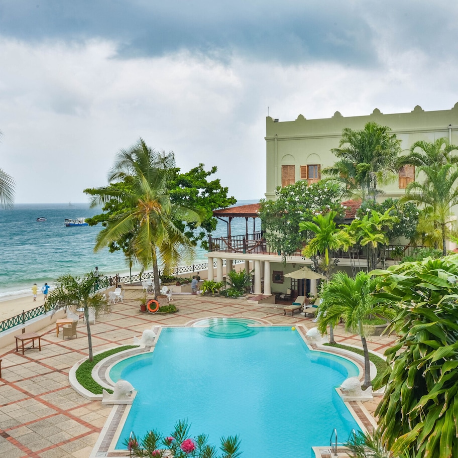 A resort with a swimming pool, beach, and ocean view.