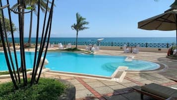 Una piscina al aire libre, sombrillas, guardavidas en la propiedad