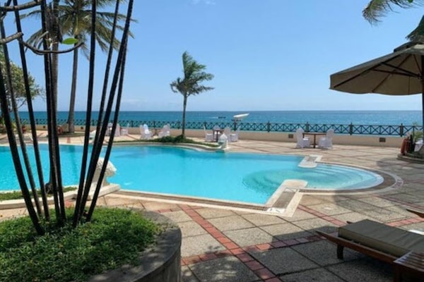 Outdoor pool, pool umbrellas, lifeguards on site