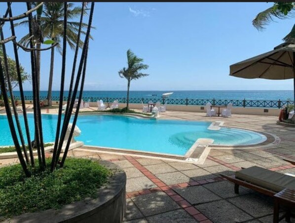 Una piscina al aire libre, sombrillas, guardavidas en la propiedad