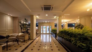 A hotel lobby with a marble floor, seating area, and a large indoor plant display. - Berr Hotel (Istanbul)