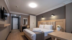 A hotel room with a large bed, a desk, a TV, and a mirror. - Berr Hotel (Istanbul)