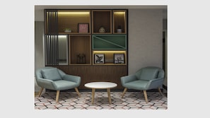 A room with two armchairs, a small round table, and a wall with built-in shelves containing various decorative items. - Holiday Inn Istanbul - Old City by IHG (Istanbul)